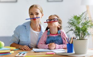 mother and daughter with pencils under nose